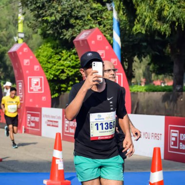 Yeni Delhi, Hindistan - 15 Ekim 2023 - Bitmek üzere olan maraton katılımcılarının bitiş çizgisini geçmek üzere olan Delhi Yarı Maratonu 2023