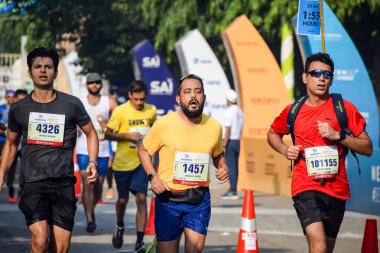 Yeni Delhi, Hindistan - 15 Ekim 2023 - Bitmek üzere olan maraton katılımcılarının bitiş çizgisini geçmek üzere olan Delhi Yarı Maratonu 2023