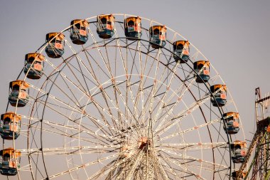 Delhi, Hindistan 'da Dussehra Mela sırasında çok renkli Dev Tekerlek' in yakın çekimi. Dev tekerlek salıncağının alt görüntüsü. Gündüz vakti renkli kamaralı dönme dolap.