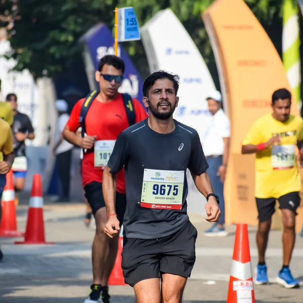 Yeni Delhi, Hindistan - 15 Ekim 2023 - Bitmek üzere olan maraton katılımcılarının bitiş çizgisini geçmek üzere olan Delhi Yarı Maratonu 2023