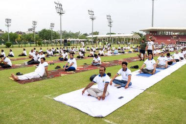 Yeni Delhi, Hindistan, 21 Haziran 2023 - Uluslararası Yoga Günü 'nde Delhi' deki Yamuna Spor Kompleksi 'nde grup Yoga egzersiz oturumu, kriket stadyumunda yoga derslerine katılan büyük bir grup yetişkin