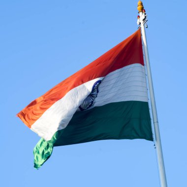 India flag flying high at Connaught Place with pride in blue sky, India flag fluttering, Indian Flag on Independence Day and Republic Day of India, tilt up shot, Waving Indian flag, Har Ghar Tiranga
