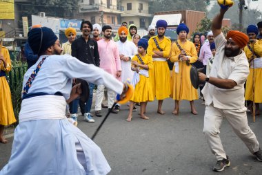 Delhi, Hindistan, 2 Ekim 2023 - Doğu Delhi bölgesinde Guru Nanak Dev, Nagar Kirtan 'ın doğum günü dolayısıyla geleneksel Nagar Kirtan, geleneksel Nagar geçit töreninde Sihler gatka ve dövüş sanatları sergiliyor