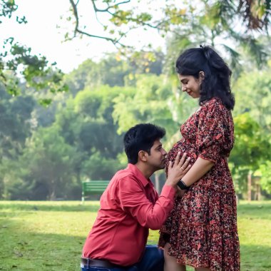 Hintli çift doğum çekimi için poz veriyor. Delhi 'deki Lodhi Road' da yeni doğan bebeğe kucak açıyorlar. Anne ve babalar çocuklarını karşıladıkları için annelik fotoğrafı çekiyorlar.