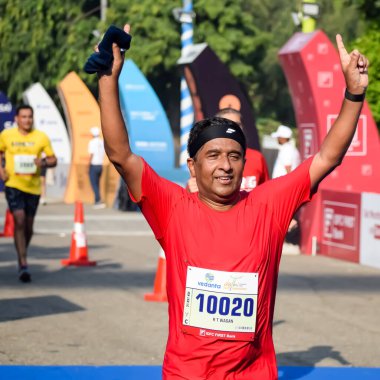 Yeni Delhi, Hindistan - 15 Ekim 2023 - Bitmek üzere olan maraton katılımcılarının bitiş çizgisini geçmek üzere olan Delhi Yarı Maratonu 2023