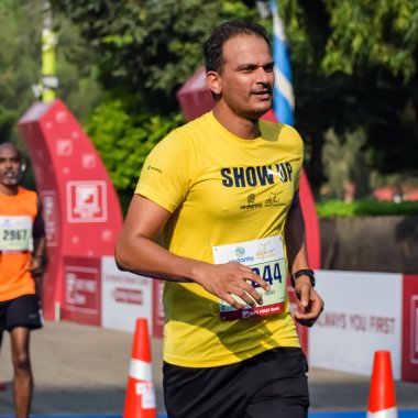 Yeni Delhi, Hindistan - 15 Ekim 2023 - Bitmek üzere olan maraton katılımcılarının bitiş çizgisini geçmek üzere olan Delhi Yarı Maratonu 2023