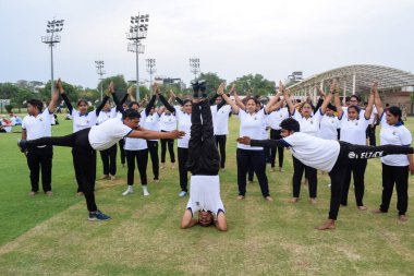 Yeni Delhi, Hindistan, 21 Haziran 2023 - Uluslararası Yoga Günü 'nde Delhi' deki Yamuna Spor Kompleksi 'nde grup Yoga egzersiz oturumu, kriket stadyumunda yoga derslerine katılan büyük bir grup yetişkin