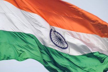 India flag flying high at Connaught Place with pride in blue sky, India flag fluttering, Indian Flag on Independence Day and Republic Day of India, tilt up shot, Waving Indian flag, Har Ghar Tiranga