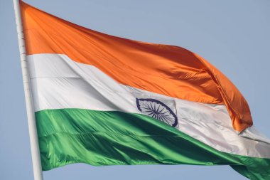 India flag flying high at Connaught Place with pride in blue sky, India flag fluttering, Indian Flag on Independence Day and Republic Day of India, tilt up shot, Waving Indian flag, Har Ghar Tiranga