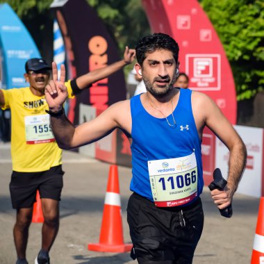 Yeni Delhi, Hindistan - 15 Ekim 2023 - Bitmek üzere olan maraton katılımcılarının bitiş çizgisini geçmek üzere olan Delhi Yarı Maratonu 2023