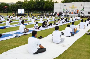 Yeni Delhi, Hindistan, 21 Haziran 2023 - Uluslararası Yoga Günü 'nde Delhi' deki Yamuna Spor Kompleksi 'nde grup Yoga egzersiz oturumu, kriket stadyumunda yoga derslerine katılan büyük bir grup yetişkin