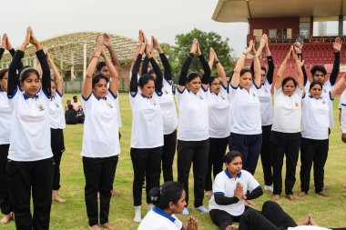 Yeni Delhi, Hindistan, 21 Haziran 2023 - Uluslararası Yoga Günü 'nde Delhi' deki Yamuna Spor Kompleksi 'nde grup Yoga egzersiz oturumu, kriket stadyumunda yoga derslerine katılan büyük bir grup yetişkin