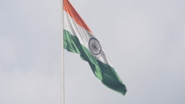 India flag flying high at Connaught Place with pride in blue sky, India flag fluttering, Indian Flag on Independence Day and Republic Day of India, tilt up shot, Waving Indian flag, Har Ghar Tiranga