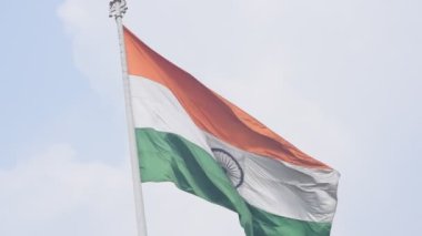 India flag flying high at Connaught Place with pride in blue sky, India flag fluttering, Indian Flag on Independence Day and Republic Day of India, tilt up shot, Waving Indian flag, Har Ghar Tiranga