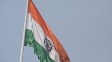 India flag flying high at Connaught Place with pride in blue sky, India flag fluttering, Indian Flag on Independence Day and Republic Day of India, tilt up shot, Waving Indian flag, Har Ghar Tiranga