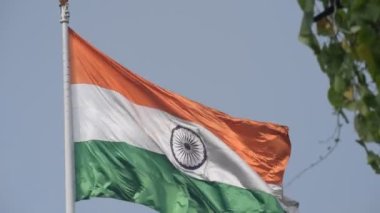 India flag flying high at Connaught Place with pride in blue sky, India flag fluttering, Indian Flag on Independence Day and Republic Day of India, tilt up shot, Waving Indian flag, Har Ghar Tiranga
