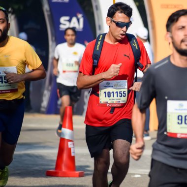 Yeni Delhi, Hindistan - 15 Ekim 2023 - Bitmek üzere olan maraton katılımcılarının bitiş çizgisini geçmek üzere olan Delhi Yarı Maratonu 2023