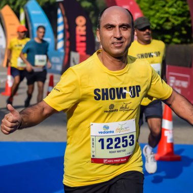 Yeni Delhi, Hindistan - 15 Ekim 2023 - Bitmek üzere olan maraton katılımcılarının bitiş çizgisini geçmek üzere olan Delhi Yarı Maratonu 2023