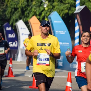 Yeni Delhi, Hindistan - 15 Ekim 2023 - Bitmek üzere olan maraton katılımcılarının bitiş çizgisini geçmek üzere olan Delhi Yarı Maratonu 2023