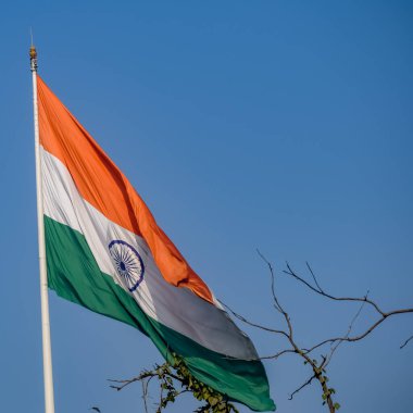 India flag flying high at Connaught Place with pride in blue sky, India flag fluttering, Indian Flag on Independence Day and Republic Day of India, tilt up shot, Waving Indian flag, Har Ghar Tiranga