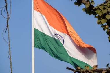 India flag flying high at Connaught Place with pride in blue sky, India flag fluttering, Indian Flag on Independence Day and Republic Day of India, tilt up shot, Waving Indian flag, Har Ghar Tiranga
