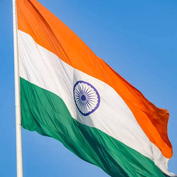 stock image India flag flying high at Connaught Place with pride in blue sky, India flag fluttering, Indian Flag on Independence Day and Republic Day of India, tilt up shot, Waving Indian flag, Har Ghar Tiranga