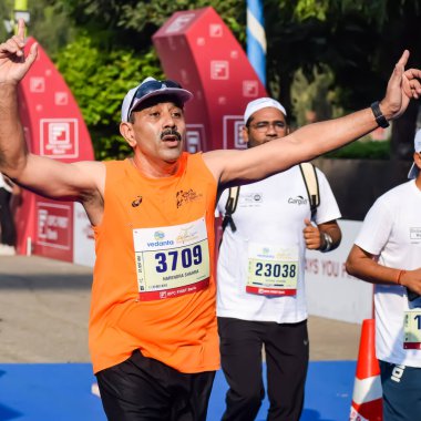 Yeni Delhi, Hindistan - 15 Ekim 2023 - Bitmek üzere olan maraton katılımcılarının bitiş çizgisini geçmek üzere olan Delhi Yarı Maratonu 2023