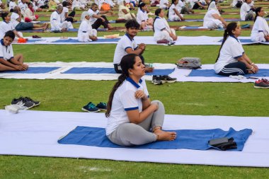 Yeni Delhi, Hindistan, 21 Haziran 2023 - Uluslararası Yoga Günü 'nde Delhi' deki Yamuna Spor Kompleksi 'nde grup Yoga egzersiz oturumu, kriket stadyumunda yoga derslerine katılan büyük bir grup yetişkin
