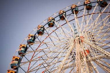 Delhi, Hindistan 'da Dussehra Mela sırasında çok renkli Dev Tekerlek' in yakın çekimi. Dev tekerlek salıncağının alt görüntüsü. Gündüz vakti renkli kamaralı dönme dolap.