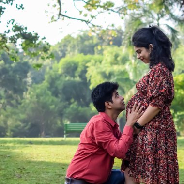 Hintli çift doğum çekimi için poz veriyor. Delhi 'deki Lodhi Road' da yeni doğan bebeğe kucak açıyorlar. Anne ve babalar çocuklarını karşıladıkları için annelik fotoğrafı çekiyorlar.