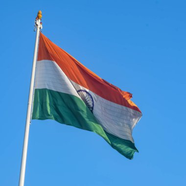 India flag flying high at Connaught Place with pride in blue sky, India flag fluttering, Indian Flag on Independence Day and Republic Day of India, tilt up shot, Waving Indian flag, Har Ghar Tiranga
