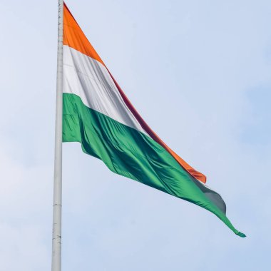 India flag flying high at Connaught Place with pride in blue sky, India flag fluttering, Indian Flag on Independence Day and Republic Day of India, tilt up shot, Waving Indian flag, Har Ghar Tiranga