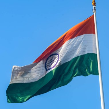 India flag flying high at Connaught Place with pride in blue sky, India flag fluttering, Indian Flag on Independence Day and Republic Day of India, tilt up shot, Waving Indian flag, Har Ghar Tiranga