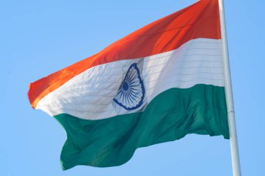 India flag flying high at Connaught Place with pride in blue sky, India flag fluttering, Indian Flag on Independence Day and Republic Day of India, tilt up shot, Waving Indian flag, Har Ghar Tiranga