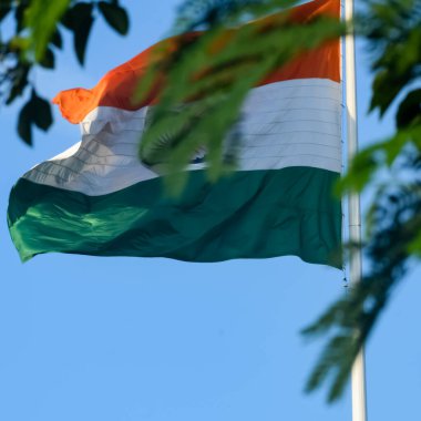India flag flying high at Connaught Place with pride in blue sky, India flag fluttering, Indian Flag on Independence Day and Republic Day of India, tilt up shot, Waving Indian flag, Har Ghar Tiranga