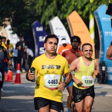 Yeni Delhi, Hindistan - 15 Ekim 2023 - Bitmek üzere olan maraton katılımcılarının bitiş çizgisini geçmek üzere olan Delhi Yarı Maratonu 2023