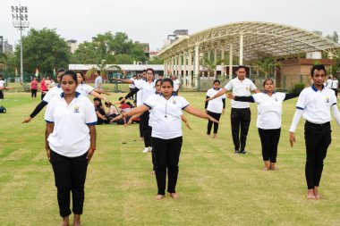 Yeni Delhi, Hindistan, 21 Haziran 2023 - Uluslararası Yoga Günü 'nde Delhi' deki Yamuna Spor Kompleksi 'nde grup Yoga egzersiz oturumu, kriket stadyumunda yoga derslerine katılan büyük bir grup yetişkin