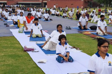 Yeni Delhi, Hindistan, 21 Haziran 2023 - Uluslararası Yoga Günü 'nde Delhi' deki Yamuna Spor Kompleksi 'nde grup Yoga egzersiz oturumu, kriket stadyumunda yoga derslerine katılan büyük bir grup yetişkin