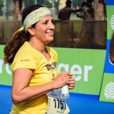 Yeni Delhi, Hindistan - 15 Ekim 2023 - Bitmek üzere olan maraton katılımcılarının bitiş çizgisini geçmek üzere olan Delhi Yarı Maratonu 2023