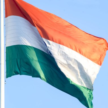 India flag flying high at Connaught Place with pride in blue sky, India flag fluttering, Indian Flag on Independence Day and Republic Day of India, tilt up shot, Waving Indian flag, Har Ghar Tiranga