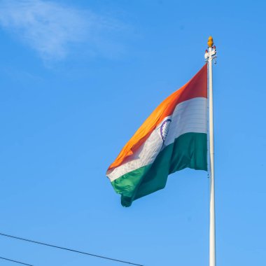 India flag flying high at Connaught Place with pride in blue sky, India flag fluttering, Indian Flag on Independence Day and Republic Day of India, tilt up shot, Waving Indian flag, Har Ghar Tiranga