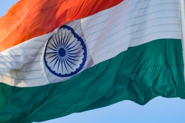 India flag flying high at Connaught Place with pride in blue sky, India flag fluttering, Indian Flag on Independence Day and Republic Day of India, tilt up shot, Waving Indian flag, Har Ghar Tiranga