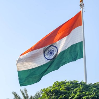 India flag flying high at Connaught Place with pride in blue sky, India flag fluttering, Indian Flag on Independence Day and Republic Day of India, tilt up shot, Waving Indian flag, Har Ghar Tiranga