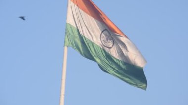 India flag flying high at Connaught Place with pride in blue sky, India flag fluttering, Indian Flag on Independence Day and Republic Day of India, tilt up shot, Waving Indian flag, Har Ghar Tiranga
