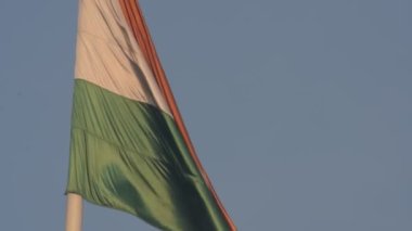India flag flying high at Connaught Place with pride in blue sky, India flag fluttering, Indian Flag on Independence Day and Republic Day of India, tilt up shot, Waving Indian flag, Har Ghar Tiranga