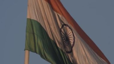 India flag flying high at Connaught Place with pride in blue sky, India flag fluttering, Indian Flag on Independence Day and Republic Day of India, tilt up shot, Waving Indian flag, Har Ghar Tiranga