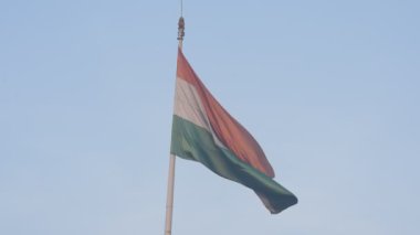 India flag flying high at Connaught Place with pride in blue sky, India flag fluttering, Indian Flag on Independence Day and Republic Day of India, tilt up shot, Waving Indian flag, Har Ghar Tiranga