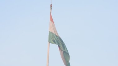 India flag flying high at Connaught Place with pride in blue sky, India flag fluttering, Indian Flag on Independence Day and Republic Day of India, tilt up shot, Waving Indian flag, Har Ghar Tiranga