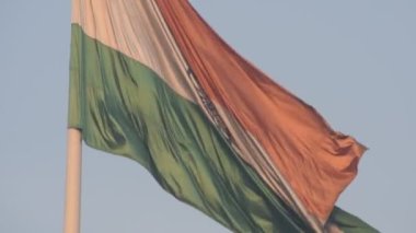 India flag flying high at Connaught Place with pride in blue sky, India flag fluttering, Indian Flag on Independence Day and Republic Day of India, tilt up shot, Waving Indian flag, Har Ghar Tiranga