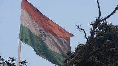 India flag flying high at Connaught Place with pride in blue sky, India flag fluttering, Indian Flag on Independence Day and Republic Day of India, tilt up shot, Waving Indian flag, Har Ghar Tiranga
